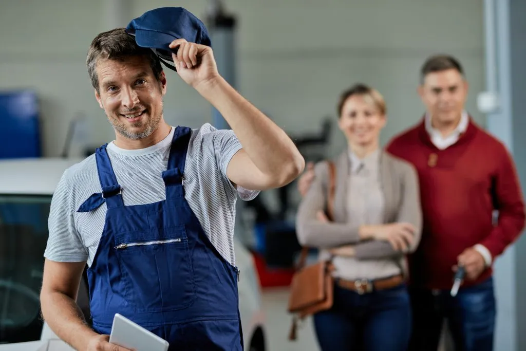 happy-auto-mechanic-taking-his-hat-while-standing-workshop-looking-camera-his-customers-are-background-1024x683 happy-auto-mechanic-taking-his-hat-while-standing-workshop-looking-camera-his-customers-are-background-1024x683